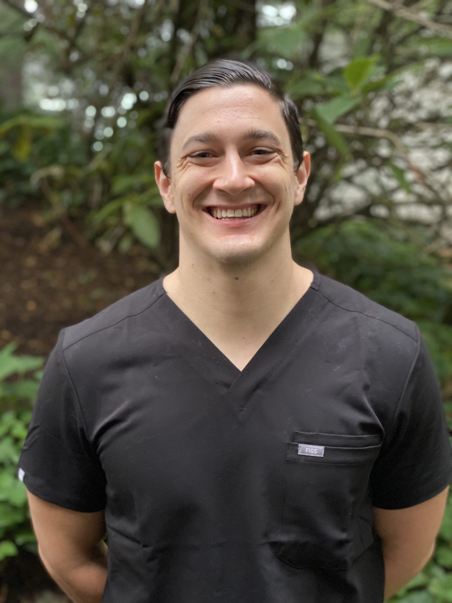 Dr. Cameron Freelove headshot Dudley Orthodontics Orthodontist Dr. Cameron Freelove from Dudley Orthodontics smiling in a black shirt.