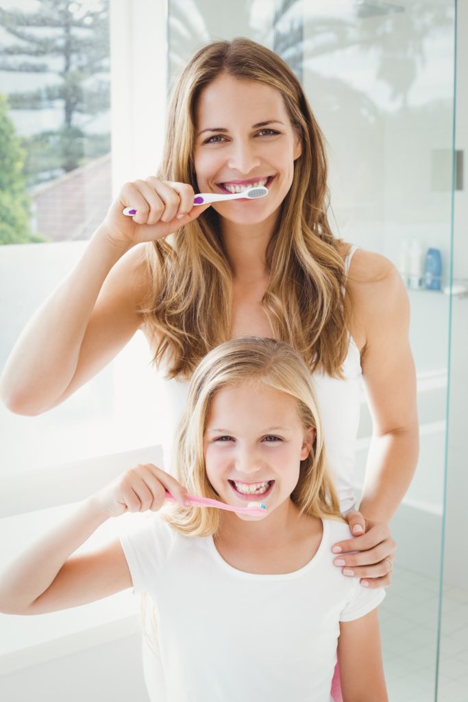 mother and daughter brushing teeth