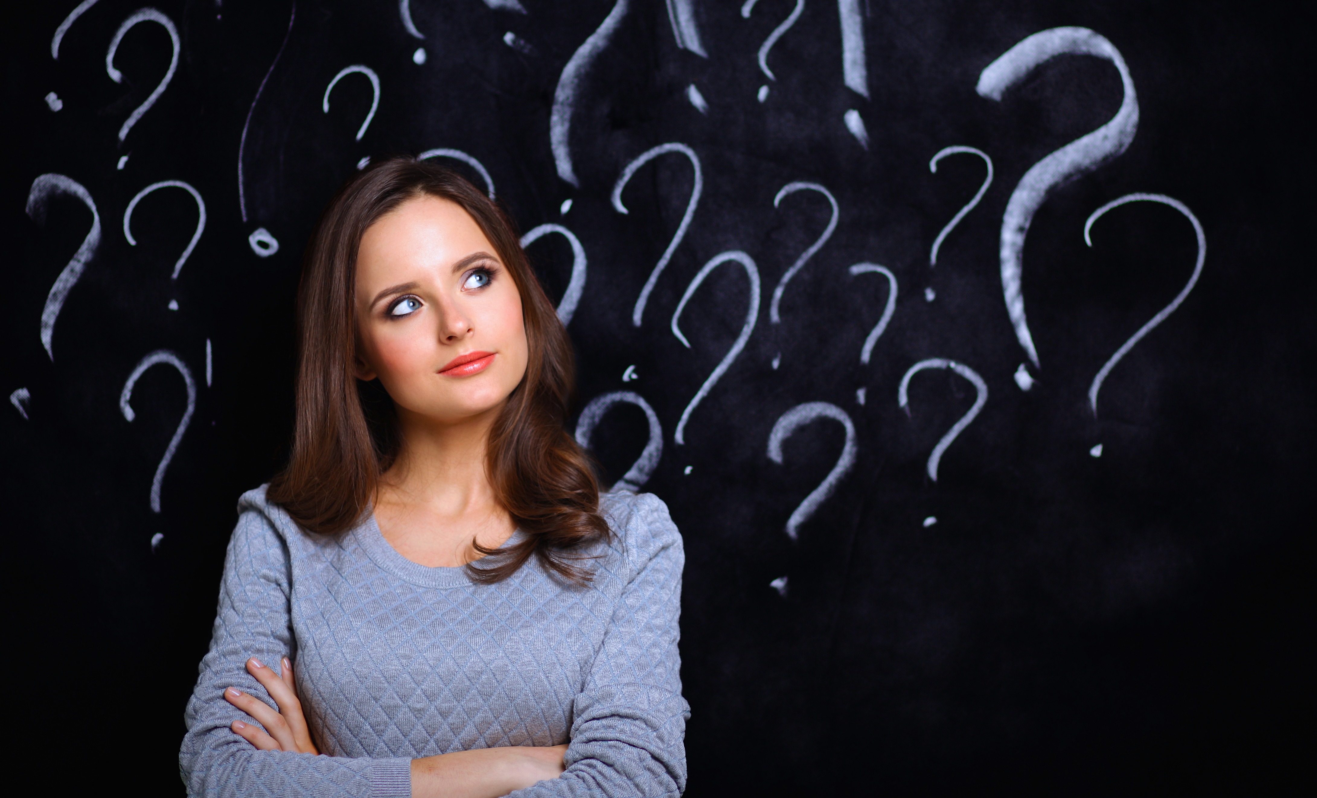 Young girl with question mark on a gray background | Dudley Smiles