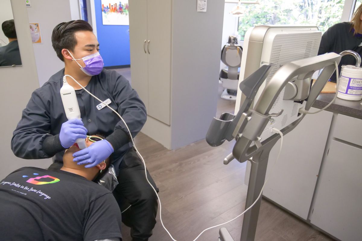 assistant scanning patient's teeth